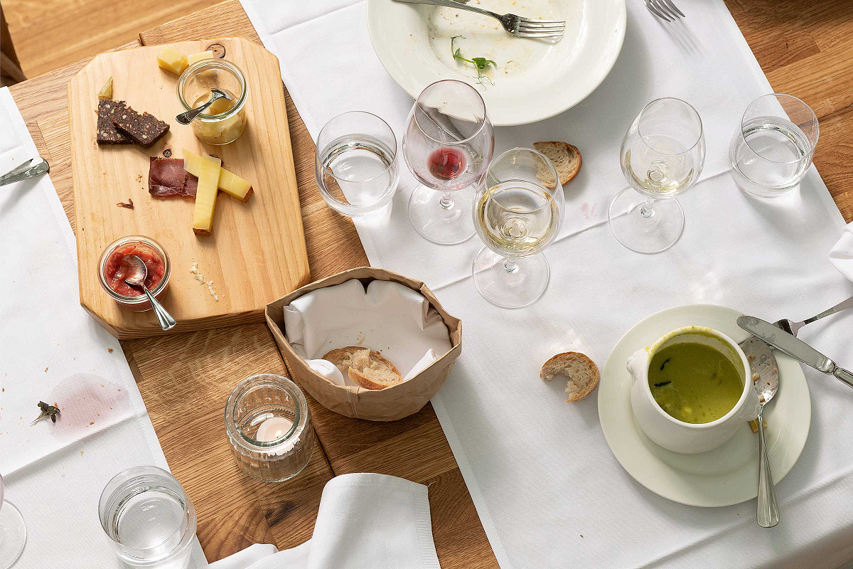 gedeckter Esstisch von oben fotografiert mit Flecken und schmutzigen Tellern